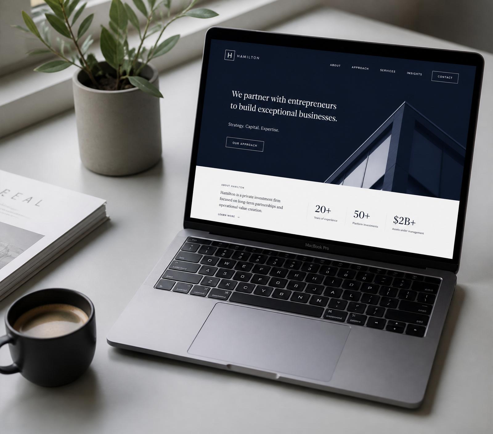 A minimalist workspace with a laptop showing a modern navy and white website design